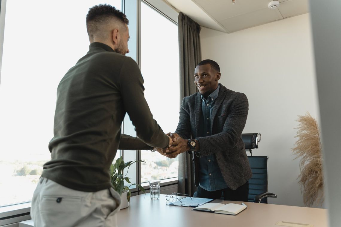 Two business professionals shaking hands in an office